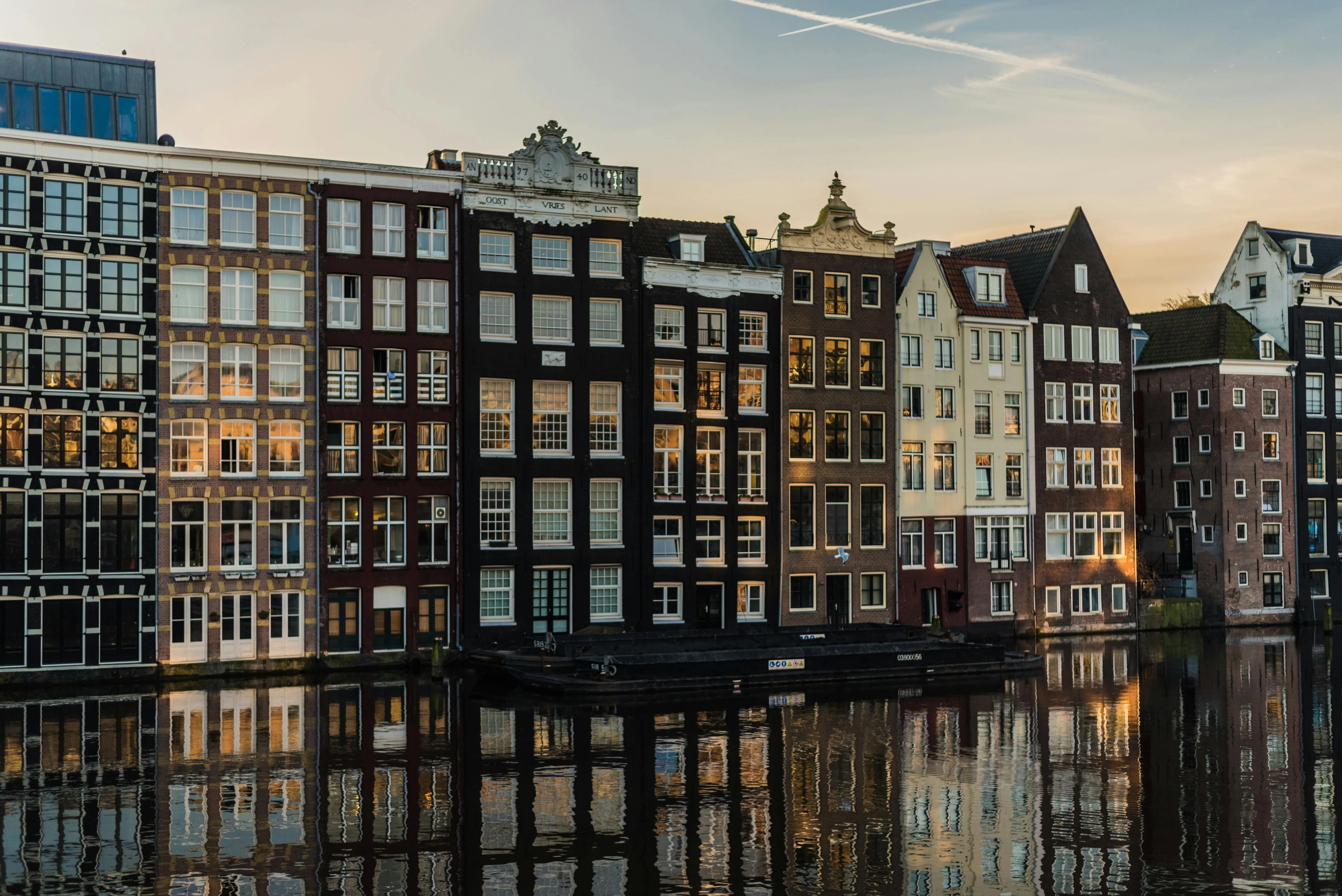 Canal houses reflected in an Amsterdam canal at golden hour