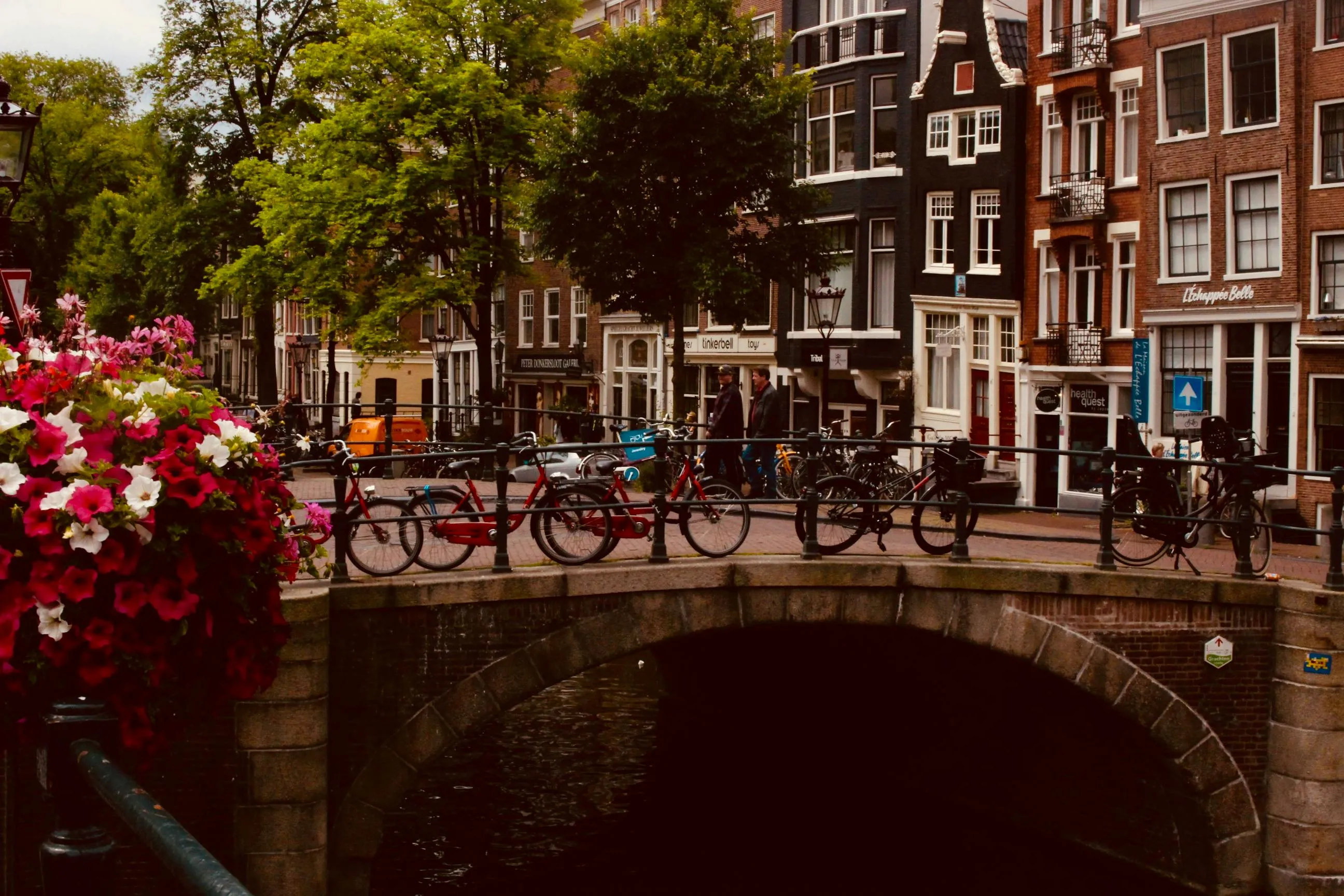 A canal bridge lined with independent shopfronts in the Jordaan
